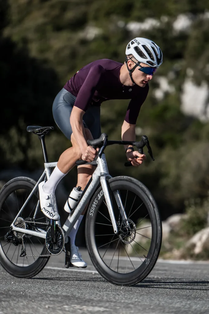 Ciclista in maglia OM bordeaux su strada